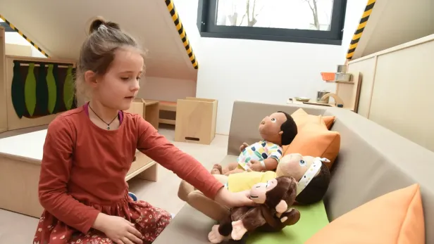 kind spielt mit einem stoffaffen