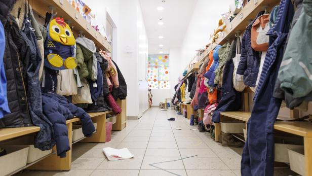 Eine Garderobe mit Jacken in einem Kindergarten.