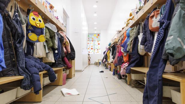 Eine Garderobe mit Jacken in einem Kindergarten.