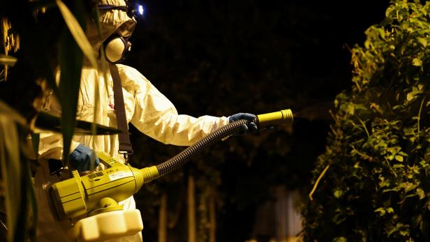 Das Bild zeigt einen Mann in einem Ganzkörperschutzanzug mit Atemmaske, der im vergangenen Sommer in einem Park in Nizza Gift gegen die asiatische Tigermücke versprüht.