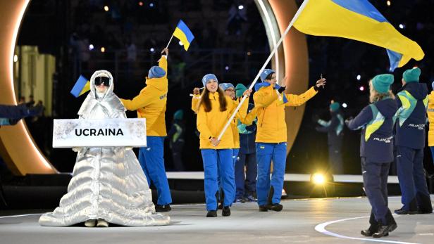 Das ukrainische Team marschiert mit blau-gelben Flaggen und einem Schild mit der Aufschrift "UCRAINA" ein.