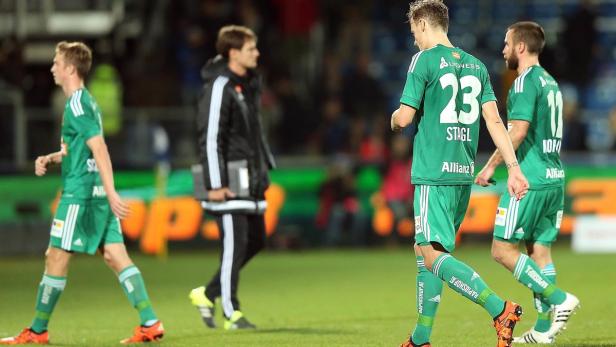 Fußballspieler in grünen Trikots betreten den Rasen.