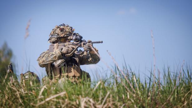 Bundesheersoldat mit Gewehr in einer Wiese