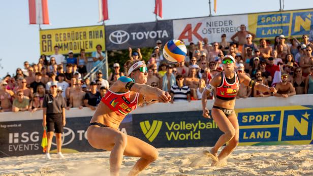 Zwei Beachvolleyballerinnen spielen.