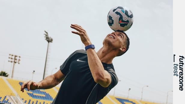 Cristiano Ronaldo mit Fitness-Tracker am Handgelenk köpft Fußball im Stadion.
