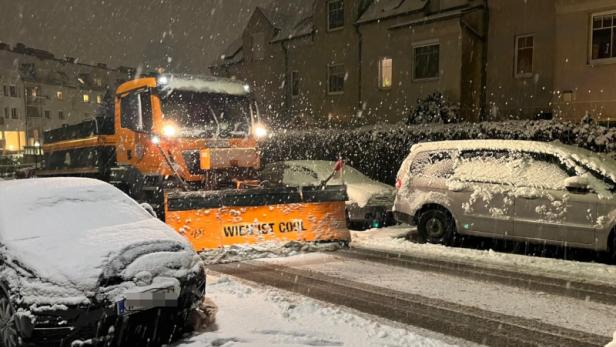 Schneeräumfahrzeug und Autos bei Schneefall