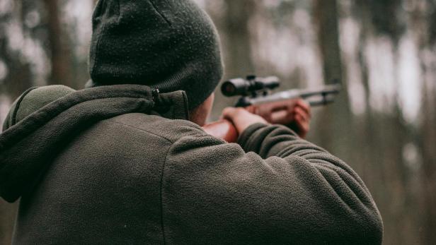 Mann mit Jagdgewehr im Wald