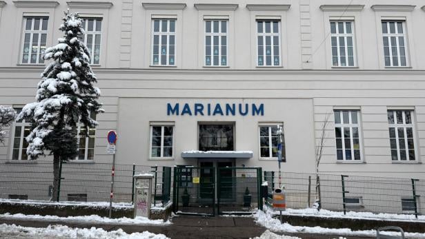 Die Fassade der Schule Marianum, davor steht ein schneebedeckter Baum.