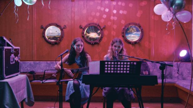 Frida Hornemann und Ida Fischer spielen Gitarre und singen.