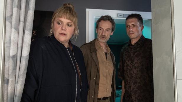 Eine Szene aus dem "Tatort": Rosa Herzog, Peter Faber und ein Zeuge stehen in einem Raum und blicken ernsthaft und angespannt in dieselbe Richtung.
