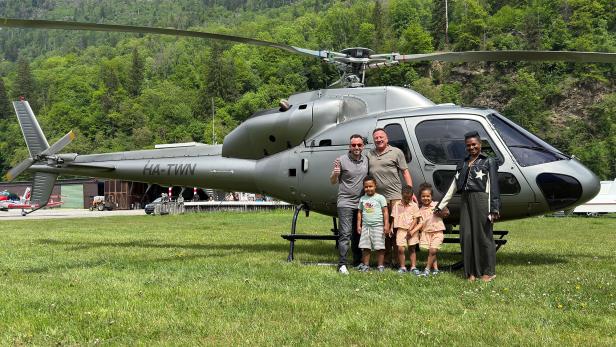 Eine Familie steht vor einem Hubschrauber 