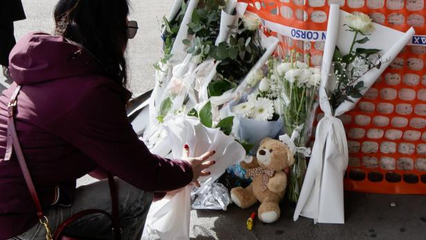 A woman pays tribute to a toddler who died after a heart transplant, outside Monaldi Hospital in Naples