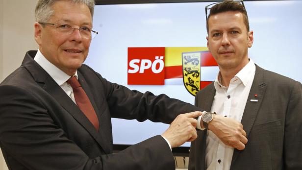 Zwei Männer stehen vor einem Bildschirm mit dem SPÖ-Logo und dem Kärntner Wappen.