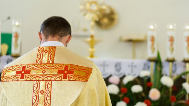 Priest of the Catholic Church in yellow clothes bows