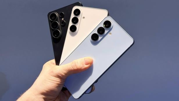 Drei Samsung Galaxy S26 Smartphones in verschiedenen Farben werden in einer Hand gehalten.