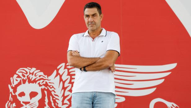 Ein Mann im weißen T-Shirt vor rotem Hintergrund