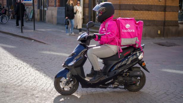 Gothenburg, Sweden - March 26, 2022: Foodora delivery man driving to delivery address