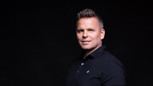 Ein Mann vor dunklem Hintergrund