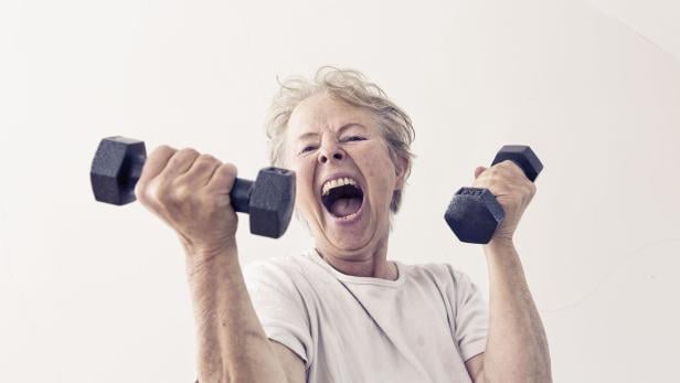  Eine aktive Seniorin trainiert mit Hanteln.