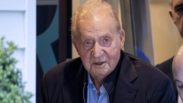 Spaniens Altkönig Juan Carlos trägt ein blaues Hemd unter einem dunklen Sakko.