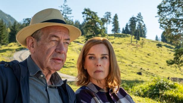 Robert Hunger-Bühler sitzt in Fernsehrolle neben Désirée Nosbusch auf einer Bergwiese