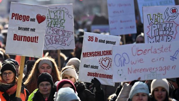 Steikende halten Transparente mit Botschaften in die Luft