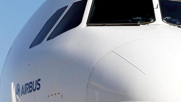 Die weiße Flugzeugnase eines Airbus mit Cockpitfenstern vor einem blauen Himmel.