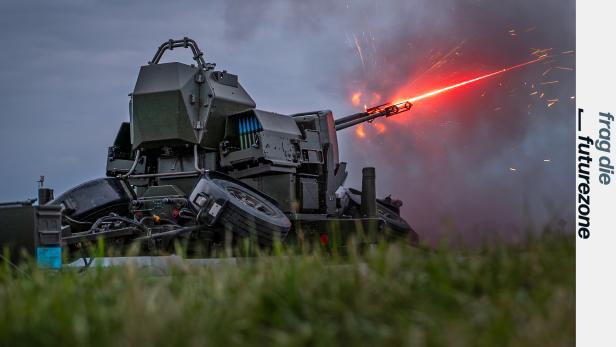 Eine 35-mm-Fliegerabwehrkanone feuert bei Dämmerung, Leuchtspur sichtbar.