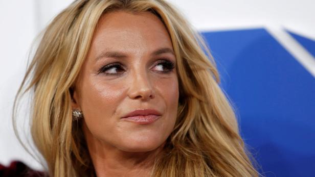Britney Spears blickt mit blonden Haaren und Ohrring nach rechts.