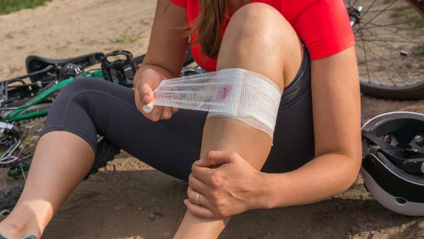 Woman with pain in knee after falling down from bicycle