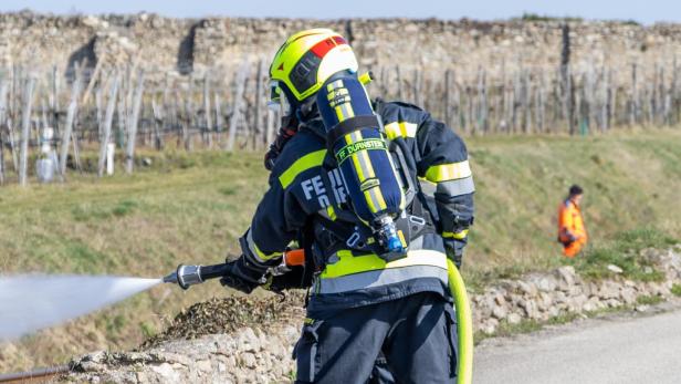 Eine Feuerwehrperson von hinten bei den Löscharbeiten.