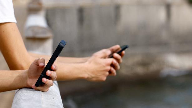 FILE PHOTO: Two 15-year-olds use social media on their mobile phones in Arinaga, on the island of Gran Canaria