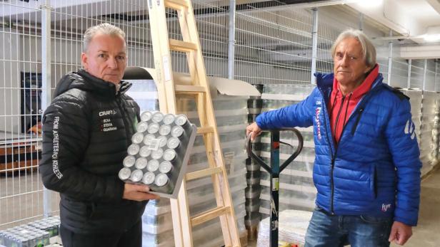 Zwei Männer stehen in einer Lagerhalle