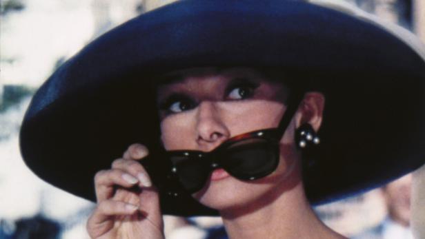 Audrey Hepburn mit Hut und Sonnenbrille im Film "Frühstück bei Tiffany".