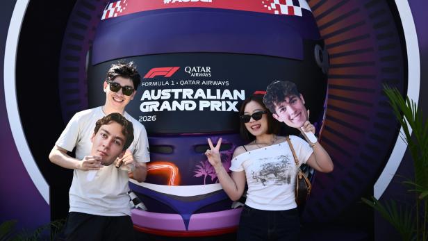 Fans in Melbourne halten Masken von George Russell und Oliver Bearman in die Kamera.