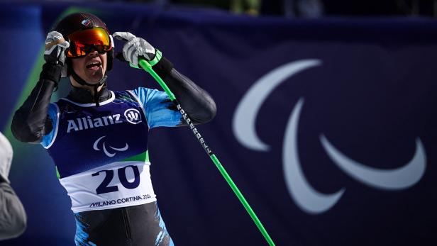 Ein Skirennläufer mit Startnummer 20 und Allianz-Logo jubelt mit Skistock und Brille.