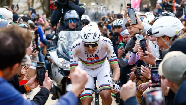 Tadej Pogacar fährt durch eine Menge von Zuschauern.