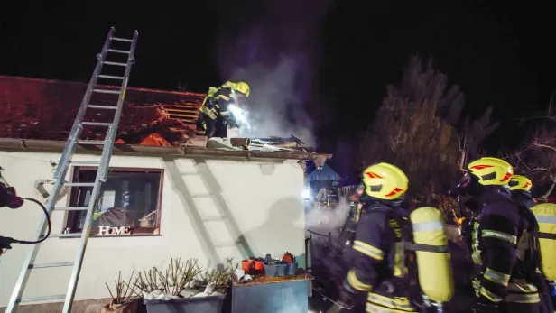 Feuerwehrleute löschen brennendes Haus