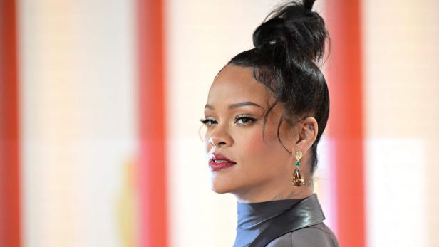 Rihanna mit hochgesteckten Haaren und auffälligen Ohrringen blickt zur Seite.