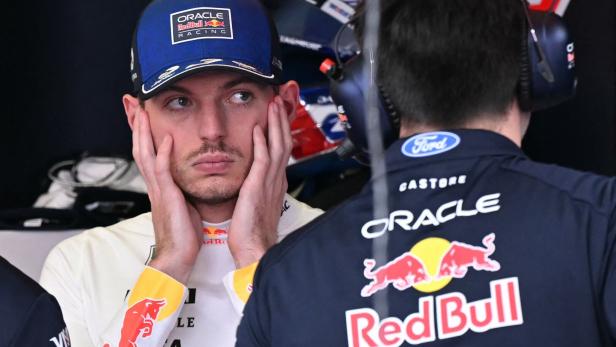 Max Verstappen in der Box im Gespräch mit einem Mechaniker.