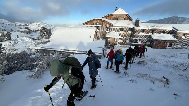 Hütte in den Bergen, Schneeschuhwanderer im vordergrund