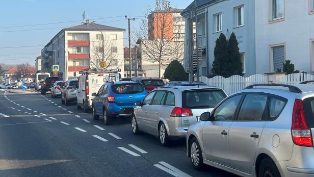 Mehrere Fahrzeuge stehen vor einem geschlossenen Bahnschranken