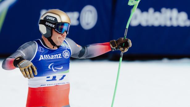 Markus Salcher mit Helm und Skibrille hält einen Skistock in der Hand.