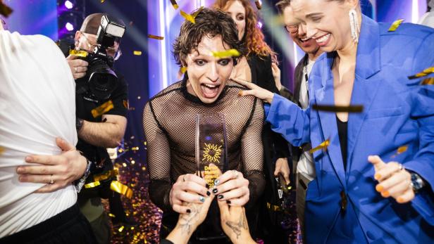 Søren Torpegaard Lund im Netzhemd hält freudestrahlend seine Trophäe nach dem dänischen ESC-Vorentscheid im Konfettiregen.