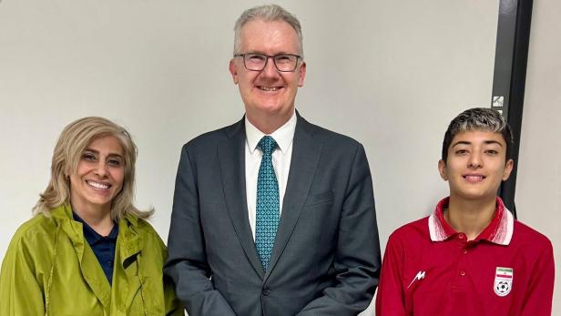 Australiens Innenminister Tom Burke mit zwei Mitgliedern des iranischen Teams.
