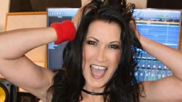 Antonia greift sich in die Haare und lächelt mit offenem Mund