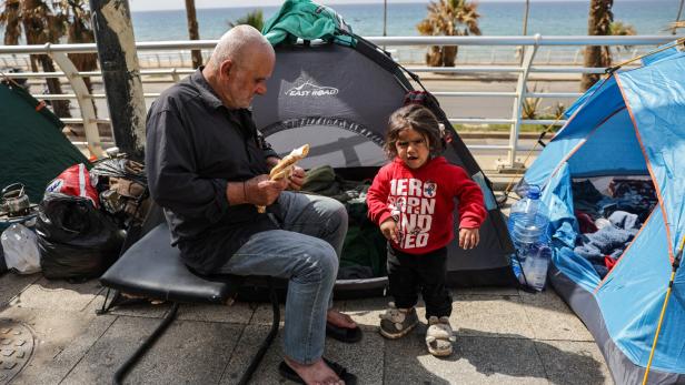 Displaced civilians set up tents along a roadside by the sea, following an escalation between Hezbollah and Israel, in Beirut