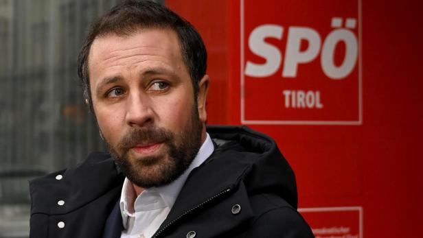 Georg Dornauer steht vor einem roten SPÖ Tirol Logo.