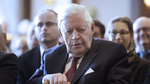 Helmut Schmidt bei einer Veranstaltung, umgeben von anderen Personen.