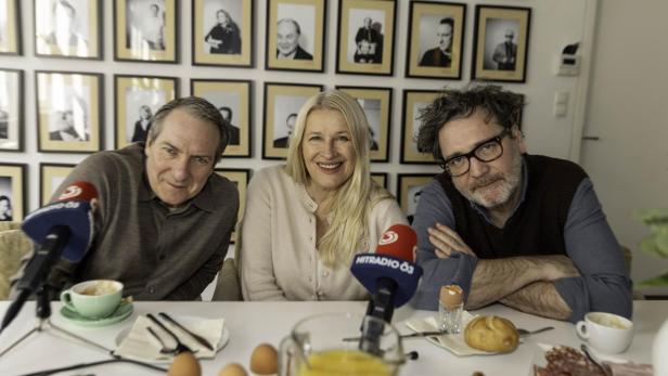 Drei Menschen sitzen an einem Frühstückstisch
